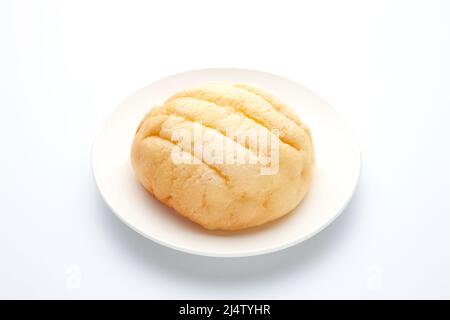 Rundes Melonenbrot auf Teller isoliert auf weißem Hintergrund Stockfoto