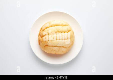 Rundes Melonenbrot auf Teller isoliert auf weißem Hintergrund Stockfoto