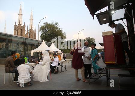 17. April 2022, Jakarta, Jakarta Capital Special Region, Indonesien: Bewohner besuchten die Istiqlal Halal Expo 2022 im Innenhof der Istiqlal Moschee mit dem Hintergrund der Kathedralkirche, Jakarta. Die Istiqlal Moschee veranstaltete die Istiqlal Halal Expo202 Veranstaltung, um das Halal Ökosystem in Indonesien zu unterstützen, sowie einen Teil der 44. milad und den Monat Ramadan zu beleben. Sandiaga Uno, die vom Minister für Tourismus und Kreativwirtschaft Sandiaga Salahaudin Uno besucht wird, hofft, dass diese Veranstaltung einen neuen Meilenstein und den ersten Schritt für die wirtschaftliche Belebung Indonesiens nach dem Co darstellt Stockfoto