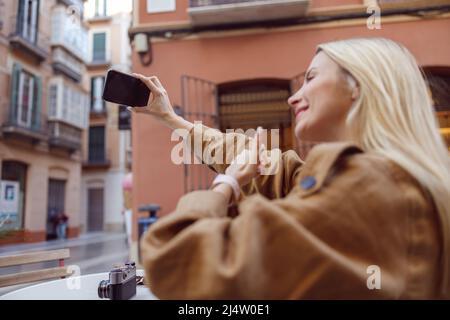 Eine Frau, die draußen Selfie gemacht hat, zeigt den Daumen nach oben Stockfoto