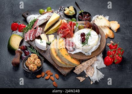 Auswahl an Vorspeisen auf dunklem Hintergrund. Mediterranes Speisekonzept. Käsesorte. Stockfoto