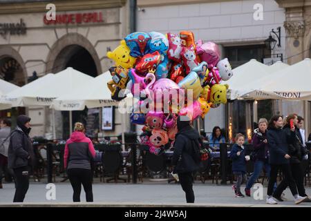 Krakau, Polen. 18. April 2022. Der Mann, der Ballons auf dem jährlichen, traditionellen Ostermarkt verkauft, findet auf dem zentralen Platz Rynek Glowny in Krakaus Altstadt statt, der im 7.. Jahrhundert gegründet wurde. (Bild: © Amy Katz/ZUMA Press Wire) Bild: ZUMA Press, Inc./Alamy Live News Stockfoto