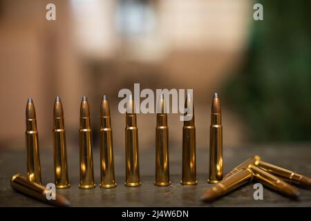 Scharfe Patronen stehen auf einer Holzkiste für das Gewehr. Stockfoto