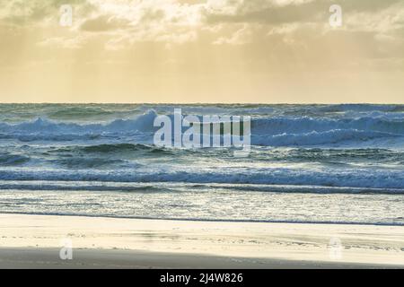 Am frühen Morgen am 75 Mile Beach, mit Lichtstrahlen, die durch die Wolken strömen, was zu einer surrealen Szene führt. Fraser Island, QLD, Australien. Stockfoto