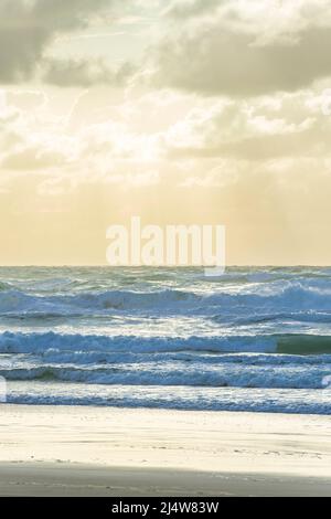 Am frühen Morgen am 75 Mile Beach, mit Lichtstrahlen, die durch die Wolken strömen, was zu einer surrealen Szene führt. Fraser Island, QLD, Australien. Stockfoto