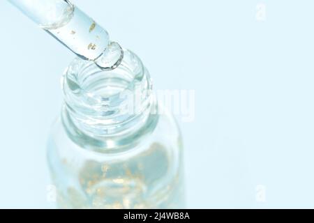 Farbfeld mit Serum-Gel-Textur. Transparenter Tropfen mit goldenem Glanz und Blasen. Gesichtspflegeprodukt. Essenz aus flüssigem Öl. Beauty Vitamin Collagen Spritzer. Organische Peeling-Behandlung. Körperpflege Stockfoto