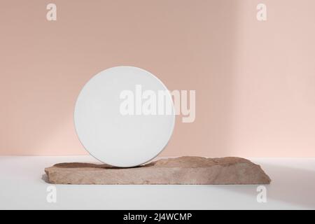 Podium für die Präsentation kosmetischer Produkte. Minimale geometrische Form und natürlicher Stein. Zylinderkugel, geometrische Kreisszene, weicher Schatten. Vorderansicht Stockfoto