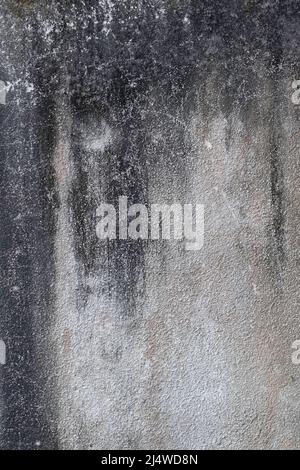 Alte Betonwand in mehreren Grau- und Schwarztönen, die ein natürliches, schwarzes Design mit Tropfen darstellen Stockfoto