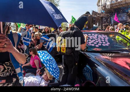 Aktivisten stoppen ein Auto, indem sie um ihn herum liegen und Mann XR Aufkleber auf dem Auto, Wir werden nicht umhergehen, ein Aussterben Rebellion Protest, dass Fi Stockfoto
