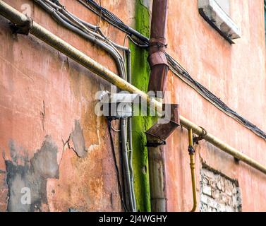 Bild einer Lampe an einer alten Wand in der Nähe eines rostigen Abflussrohres Stockfoto