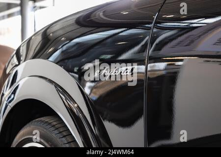 Nahaufnahme des Hybrid-Schildes aus dem Elektroauto mit Hybridmotor Stockfoto