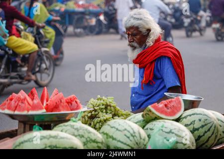 Ein alter weißhaariger Mann, der Wassermelonen aus seinem Wagen in Trichy, Tamil Nadu, Indien, verkauft Stockfoto