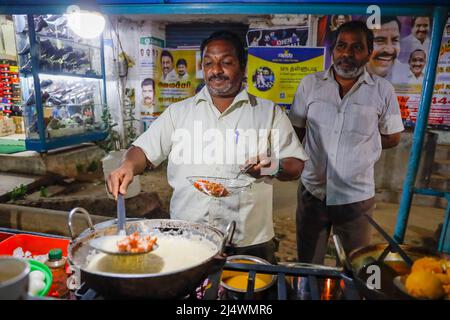 Mann im Street Food Stall, der würzige Blumenkohlsuppe in Trichy, Tamil Nadu, Indien, zubereitet Stockfoto