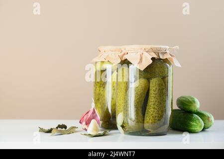 Gemüsekonserven Gurke in Gläsern auf beigem Hintergrund. Hausgemachte Ernte Herbst Vorbereitungen. Nahaufnahme. Speicherplatz kopieren. Stockfoto