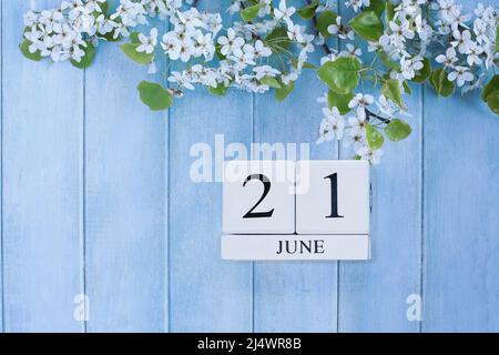 Sommersonnenwende. Schöner weißer Baum blüht auf einem ruhigen, blauen, rustikalen Holzhintergrund. Kalenderblöcke für Juni 21.. Bild von oben aufgenommen. Stockfoto