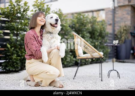 Porträt einer Frau mit ihrem Hund im Hinterhof Stockfoto