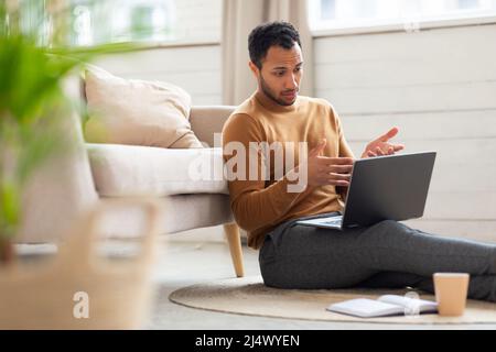 Arabischer Mann mit Laptop macht Videoanruf Stockfoto