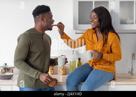 Junges Afroamerikanisches Paar Mit Spaß Beim Essen Snacks In Der Küche Stockfoto