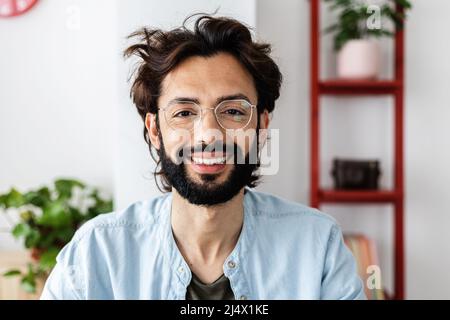 Erfolgreicher junger Unternehmer, der bei einem Videoanruf die Kamera anlächelt Stockfoto