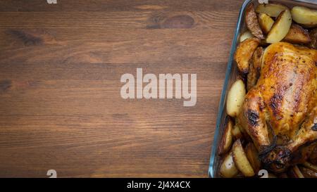 Rösten Sie Gans oder Huhn, gefüllt mit gebackenen Äpfeln in einer Pfanne auf dunklem Holzgrund, ein festliches Weihnachtsrezept. Rustikales Design. Draufsicht w Stockfoto