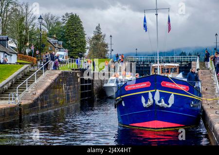 Der Touristenkreuzer Scottish Highlander mit anderen kleineren Booten, die ihren Weg durch den Caledonian Canal schlössern und in Loch Ness, Schottland, einschiffen Stockfoto