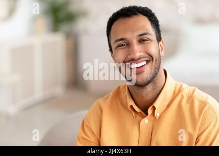 Porträt eines lächelnden jungen Mannes, der vor der Kamera posiert Stockfoto