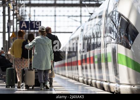 18. April 2022, Hessen, Frankfurt/Main: Reisende mit Gepäck laufen am Frankfurter Hauptbahnhof entlang eines Zuges. An besonders stark frequentierten Hauptbahnhöfen stehen zusätzliche Mitarbeiter am Osterwochenende und am Ostermontag zur Verfügung, um den Gästen beim Umsteigen und beim Ansteigen zu helfen. Foto: Hannes Albert/dpa Stockfoto