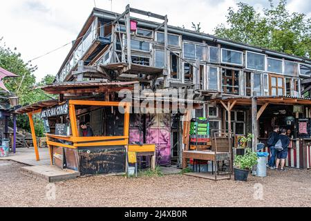 Der Vegan Gyros Stall verkauft vegetarisches Essen in der Holzmarktstraße Holzmarkt25, Friedrichshain-Berlin der Holzmarkt ist ein Kooperatives Projekt für Kreative, das von ehemaligen Anti-Gentrification-Bar25-Clubregenten betrieben wird. Es beherbergt Katerblau Nachtclub, Pampa Beach Bar, Fame Restaurant, Galerien, Bars, Geschäfte, Studios & Mörchenpark am Flussufer Gemeinschaftsgarten. Das Gebiet an der Spree in der Nähe des Berliner Ostabbahnhofs war im Jahr 1990s eine Industriebrache und wurde wie ähnliche Orte für kreative Zwecke genutzt. Juval Dieziger und Christoph Klenzedorf eröffneten den Nachtclub Bar25 auf dem Gelände. Die Gegend war bald ein Stockfoto