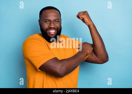 Portrait von attraktiven fröhlichen Kerl demonstriert starke Muskeln Training isoliert über hellen blauen Hintergrund Stockfoto