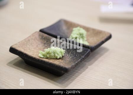 Die würzigen grünen Wasabi in den kleinen schwarzen Gerichten. Stockfoto