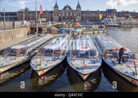 Vor dem Hauptbahnhof in amsterdam-holland vertäuten Touristenboote Stockfoto