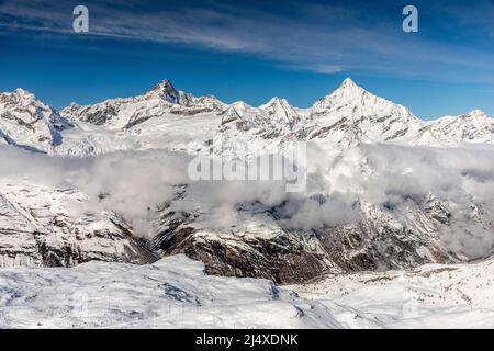 Luftaufnahme vom Gipfel des Gornergrat, umgeben von schneebedeckter Bergkette und Wolke am sonnigen Tag, Zermatt, Schweiz. Stockfoto