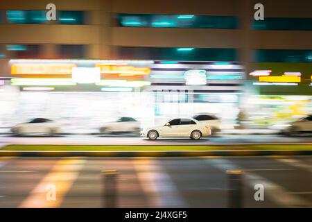 Speeding White Car Fast Driving In City Street. Hintergrund Für Bewegungsunschärfe Stockfoto