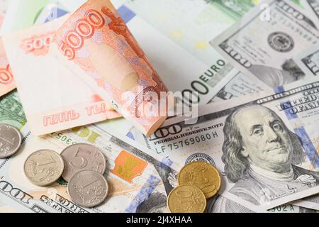 Papiergeld-Banknoten von 100 Euro, 100 us-Dollar, wirbeln russischen Rubel und Münzen. Nahaufnahme. Stockfoto