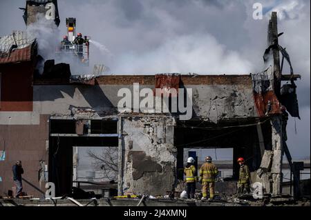 Lviv, Lviv, Ukraine. 18. April 2022. Feuerwehrmänner sahen, während sie das Feuer in der Reifenwerkstatt lösten. Am Morgen wurden in Lemberg, Berichten zufolge, vier Raketenangriffe durchgeführt, die die militärische Infrastruktur und eine stark beschädigte Reifenwerkstatt trafen. Angaben zufolge starben 7 Zivilisten und fast 11 wurden verletzt. (Bild: © Valeria Ferraro/ZUMA Press Wire) Stockfoto