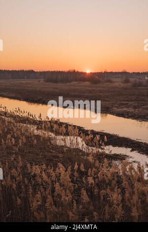 Sonnenuntergang über dem schmalen Fluss im Frühling Stockfoto