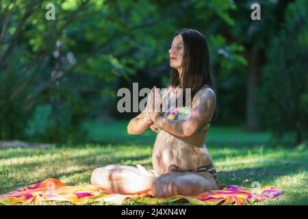Schwanger junge Frau macht Yoga im Park Stockfoto