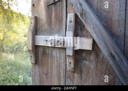 Antikes Schiebeschloss aus Holz an der Scheunentür Stockfoto
