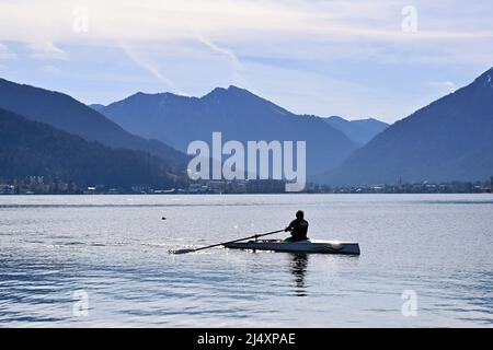 Rottach Egern, Deutschland. 18. April 2022. Ostern 2022 am Tegernsee. Blick von Bad Wiessee auf den Tegernsee und Rottach Egern. Ein Ruderer ruht am 18.. April 2022 über den See, Frühling, Sonnenschein, Landschaft, Berge, Alpen, Berge. Kredit: dpa/Alamy Live Nachrichten Stockfoto