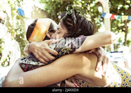 Zwei junge alternative Freunde umarmen sich in der sommerlichen Natur Stockfoto