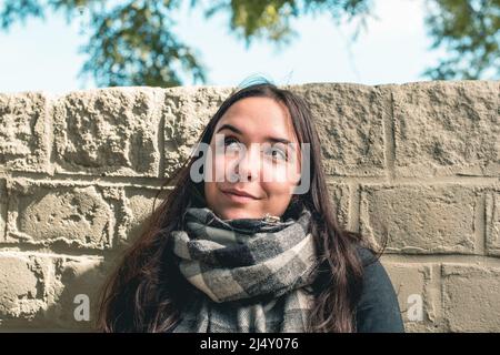 Junge schöne Frau lächelt und schaut auf wie eine Idee Stockfoto