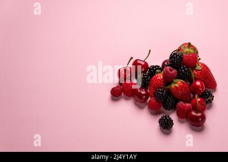 Nahaufnahme von roten Früchten auf rosa Hintergrund Stockfoto