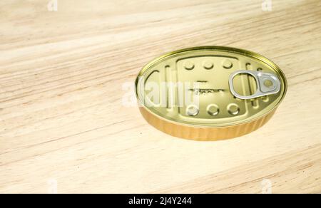 Goldene Dose von konservierten Lebensmitteln auf Holztisch Hintergrund Stockfoto