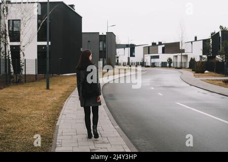 Im Frühling geht eine junge Frau durch die Straße. Stockfoto