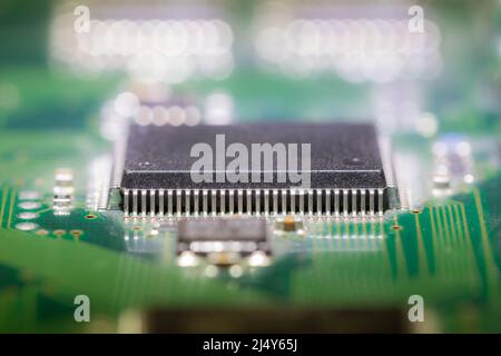 Makroaufnahme eines schwarzen Computerchips auf einer grünen Platine Stockfoto