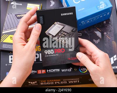 Tambow, Russische Föderation - 07. April 2022 Eine Frau hält eine Box mit einer Samsung SSD 980 pro m2 über andere Boxen mit brandneuen Komponenten in Th Stockfoto