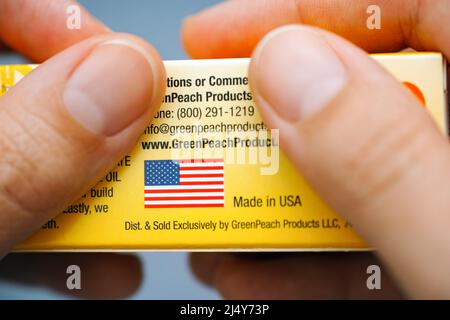 Tambow, Russische Föderation - 09. Juli 2016 Eine Frau hält den Karton GreenPeach Products mit dem Text Made in USA und der Flagge USA. Stockfoto