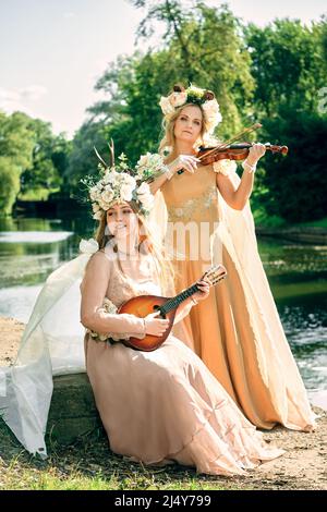 Duett von Frauen, die in der Natur Gitarre und Violine spielen Stockfoto