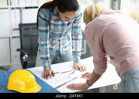 Zwei Architektinnen untersuchen den Bauplan für den Hausbau Stockfoto