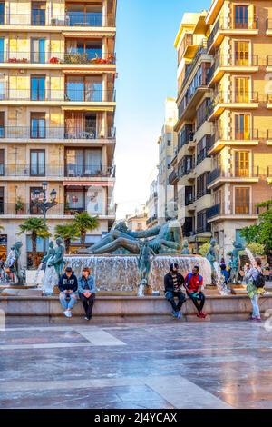 Touristen am Turia-Brunnen auf dem Platz der Jungfrau. Die Skulptur zeigt Neptun. Der Brunnen ist auch als Fuente del Tribunal De Aguas bekannt. I Stockfoto